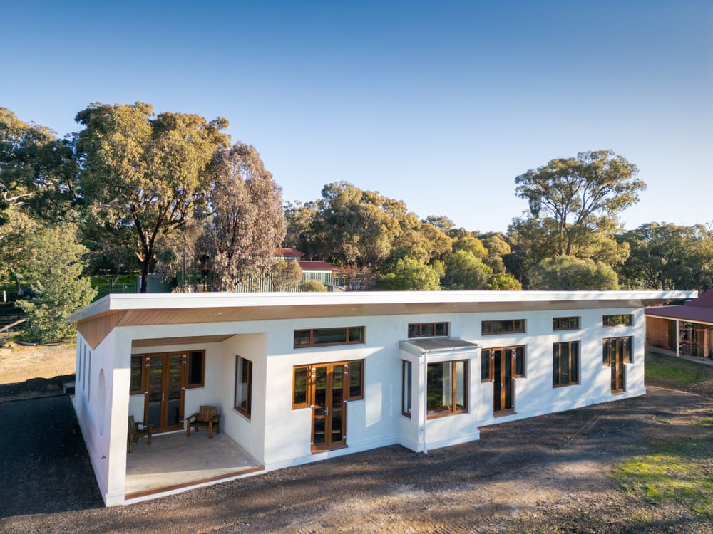 Aerial view of the Castlemaine hempcrete home showing the full north-facing roof form and deep wrap-around eaves